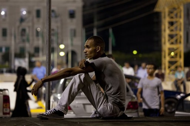 In this photo taken on a government-organized tour, a young man sits at the main Green Square Monday in Tripoli, Libya.